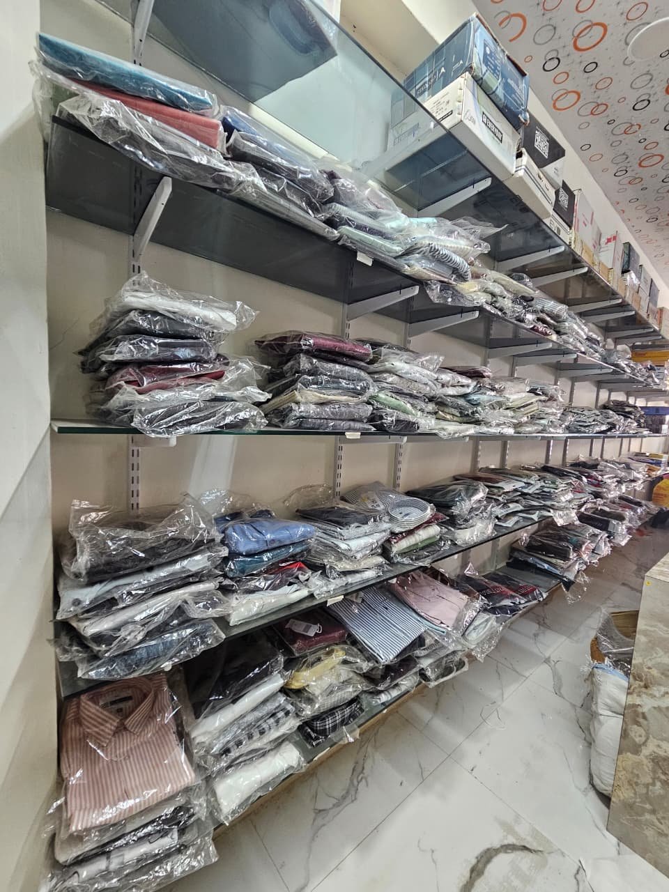 Men's shirts displayed on shelves inside Shivang Fashion